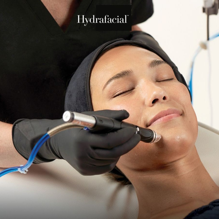 Person receiving Hydrafacial treatment with a Hydrafacial device.